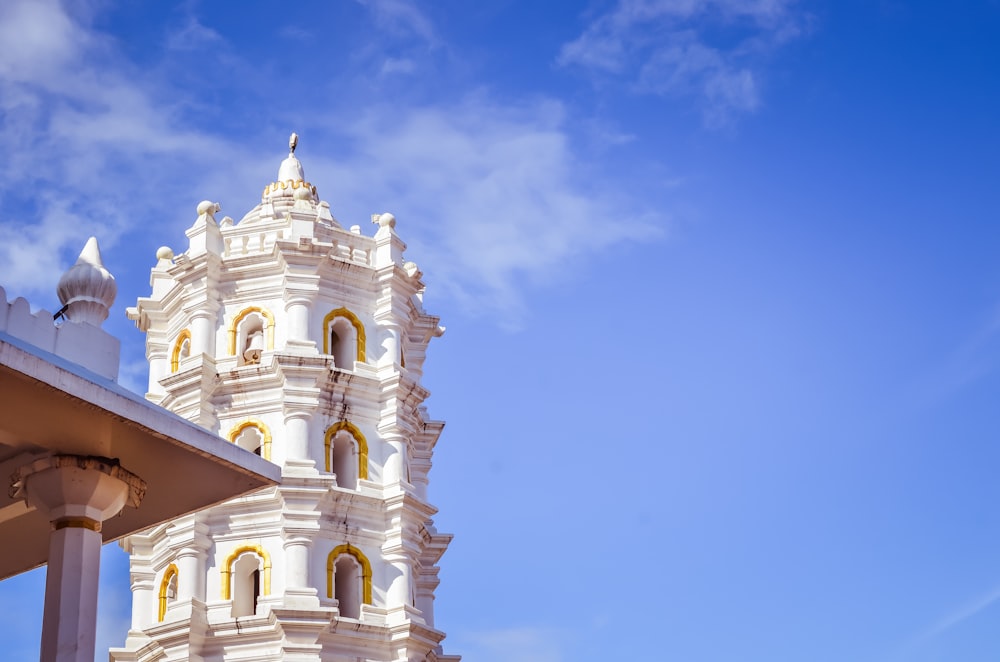 white and yellow tower building under blue and white skies during daytime