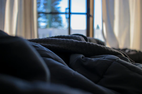 A peaceful morning scene with soft light filtering through sheer curtains over a cozy meditation corner.