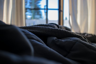 Sunlight filtering through sheer curtains onto a peaceful bedroom with neutral linens.
