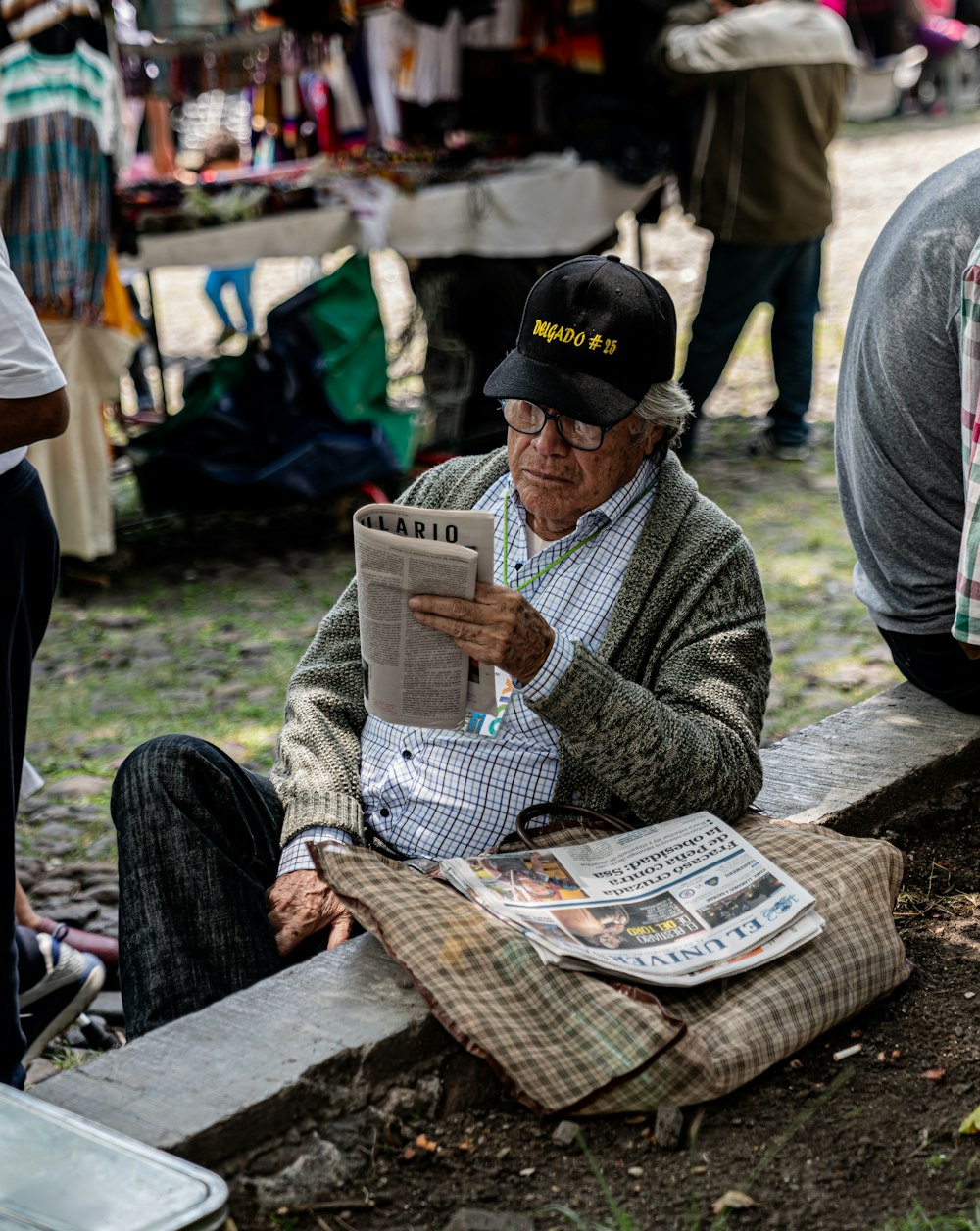 man reading newspaper by stall at daytime