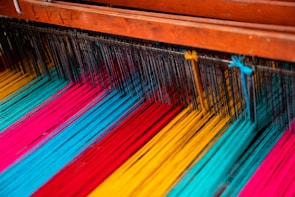 Rows of colorful threads and fabrics neatly arranged in the Loominex studio.