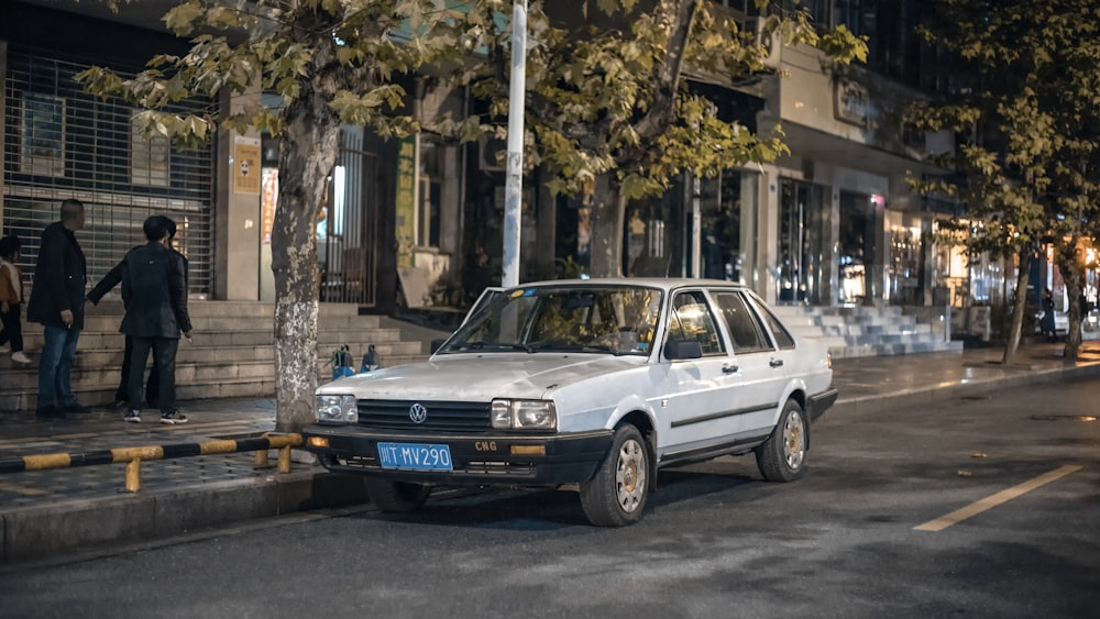 white sedan on sidewalk