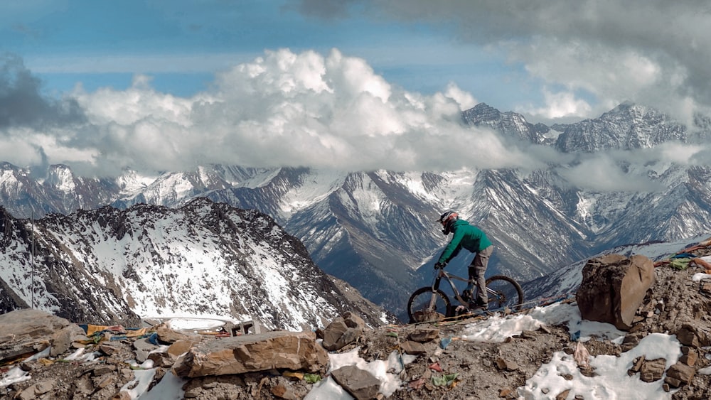 man riding bicycle top of mountain