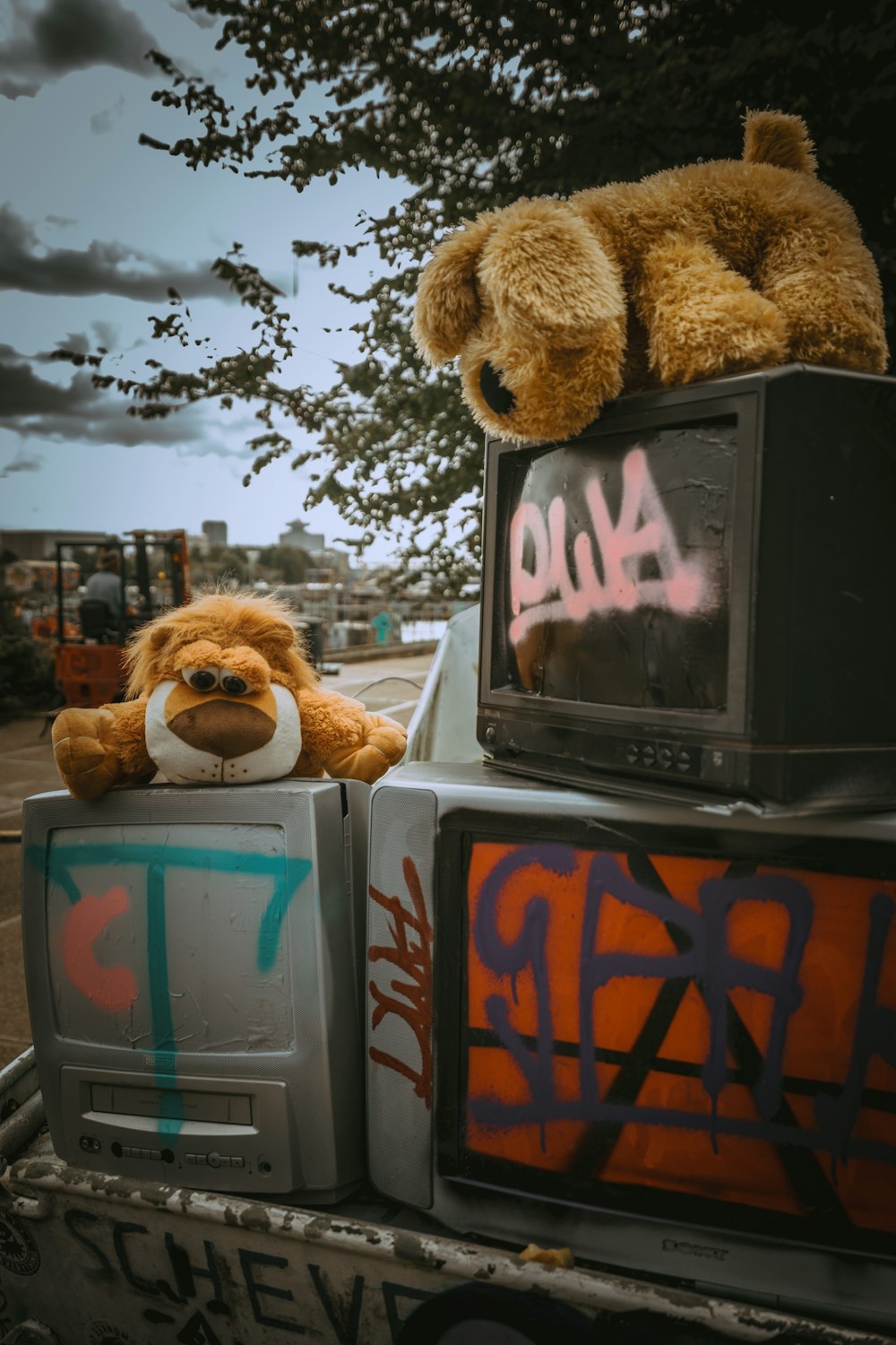 brown dog plush toy on top of black CRT TV