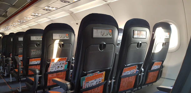 Students practicing cabin crew safety drills in a bright training room.