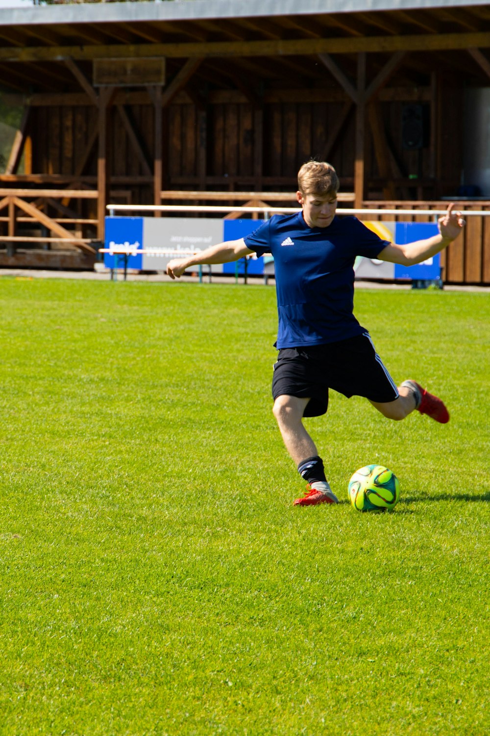 uomo che calcia pallone da calcio