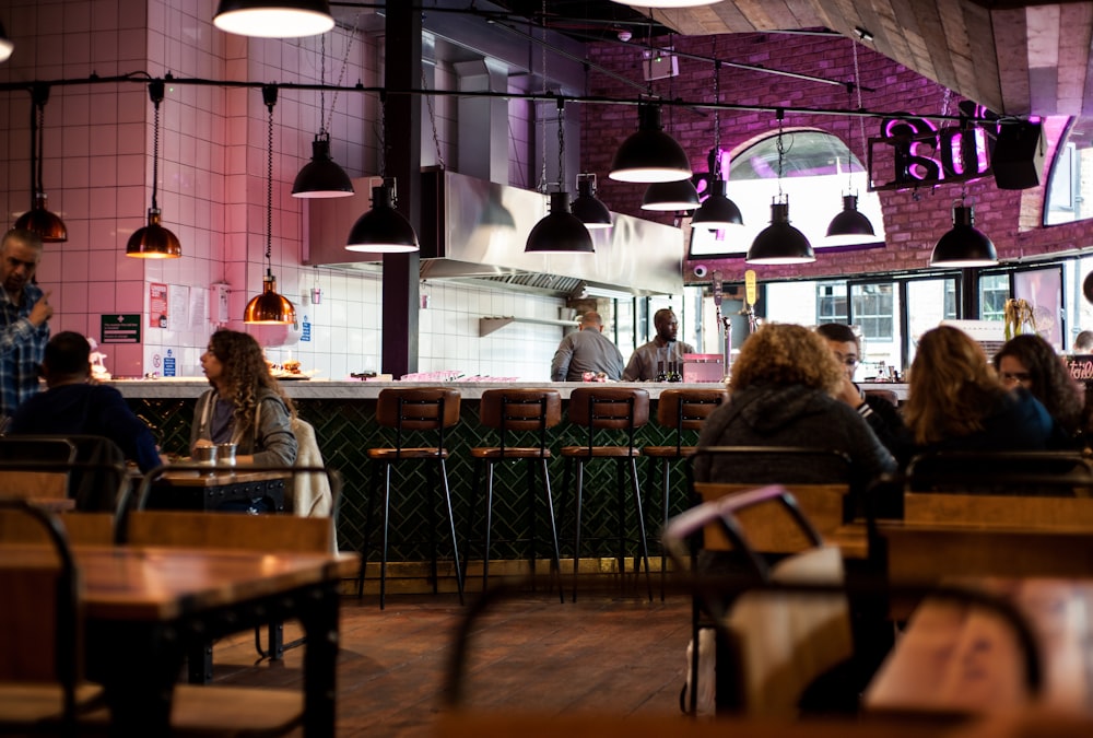 people sitting inside and others are standing in restaurant