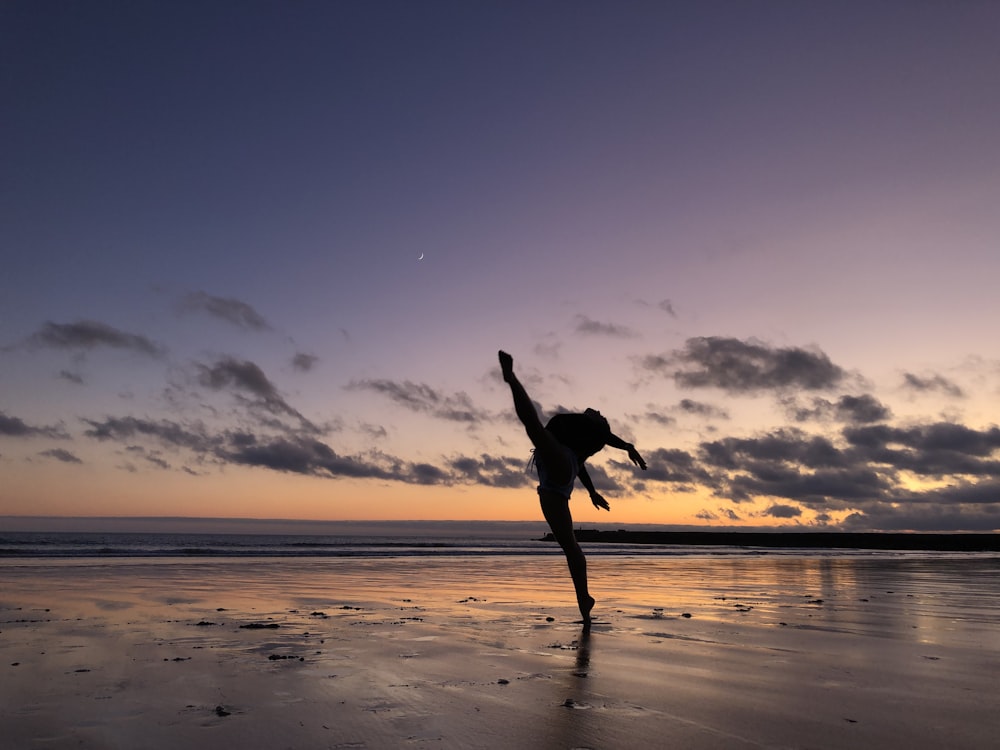 silhouette of woman dancing on the seashore
