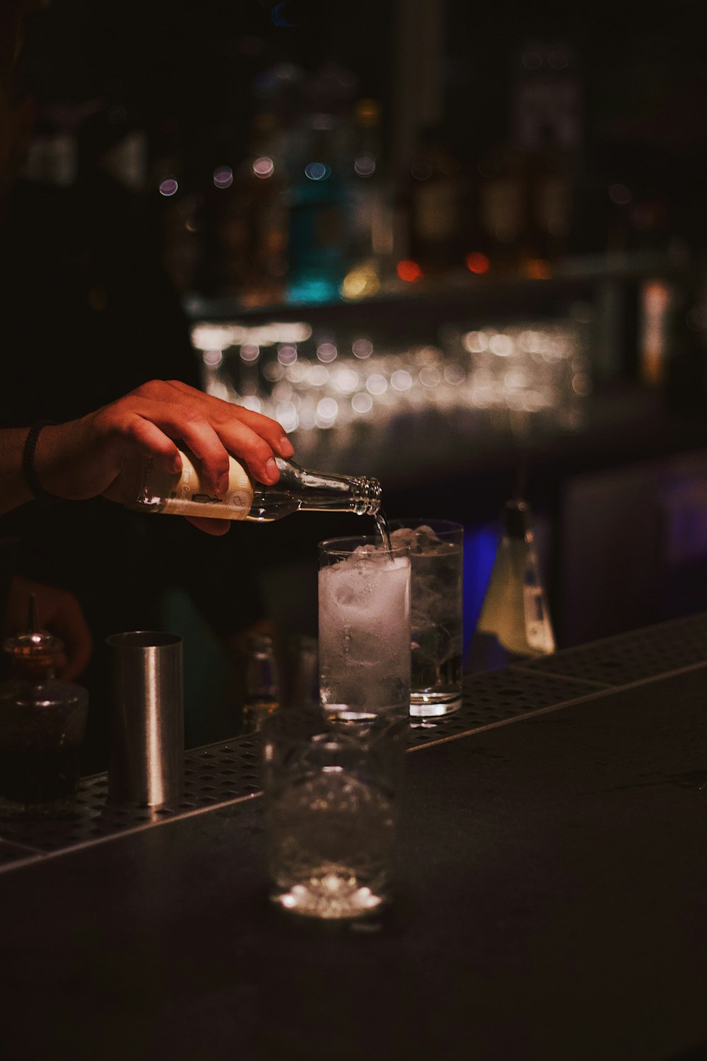 person pouring drinking glass with ice