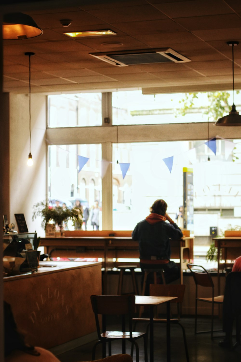 person sits on chair near tables