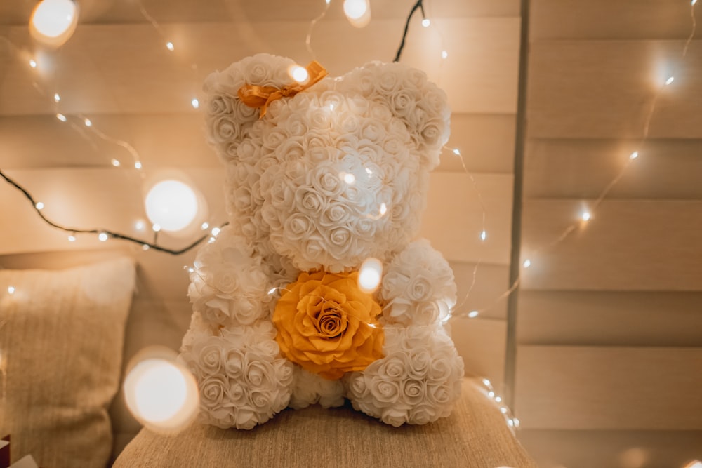 white and yellow rosette bear plush toy