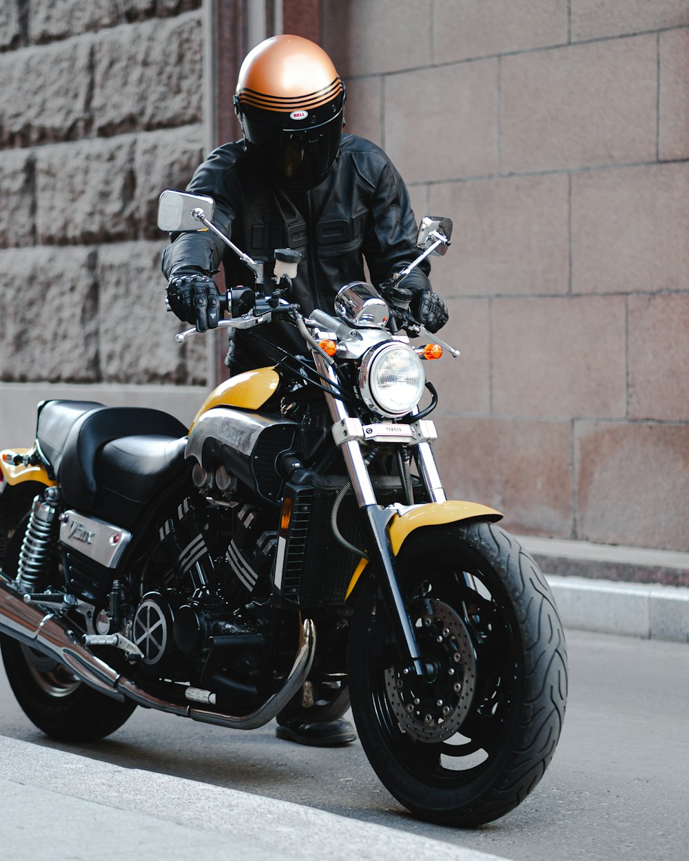 uomo in piedi accanto alla fotografia ravvicinata della motocicletta nera e gialla