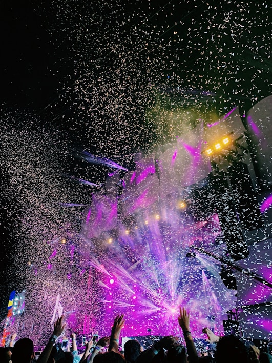 A vibrant close-up of colorful concert tickets fanned out on a wooden table.