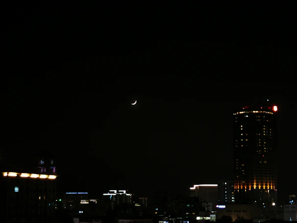A nighttime Paris skyline with a crescent moon glowing above, hinting at the brand’s inspiration.