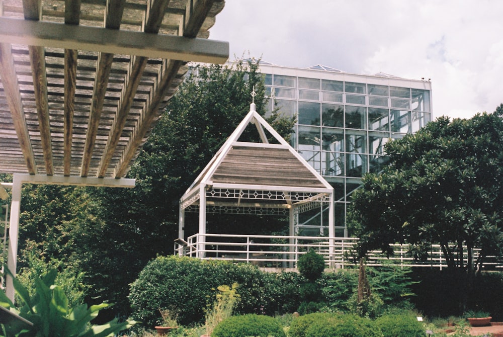 green trees near building under cloudy sky