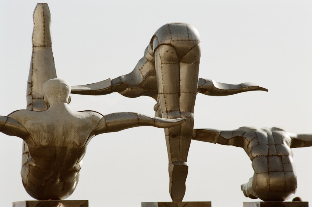 three gold-colored diving position statues