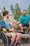smiling man giving man beer can