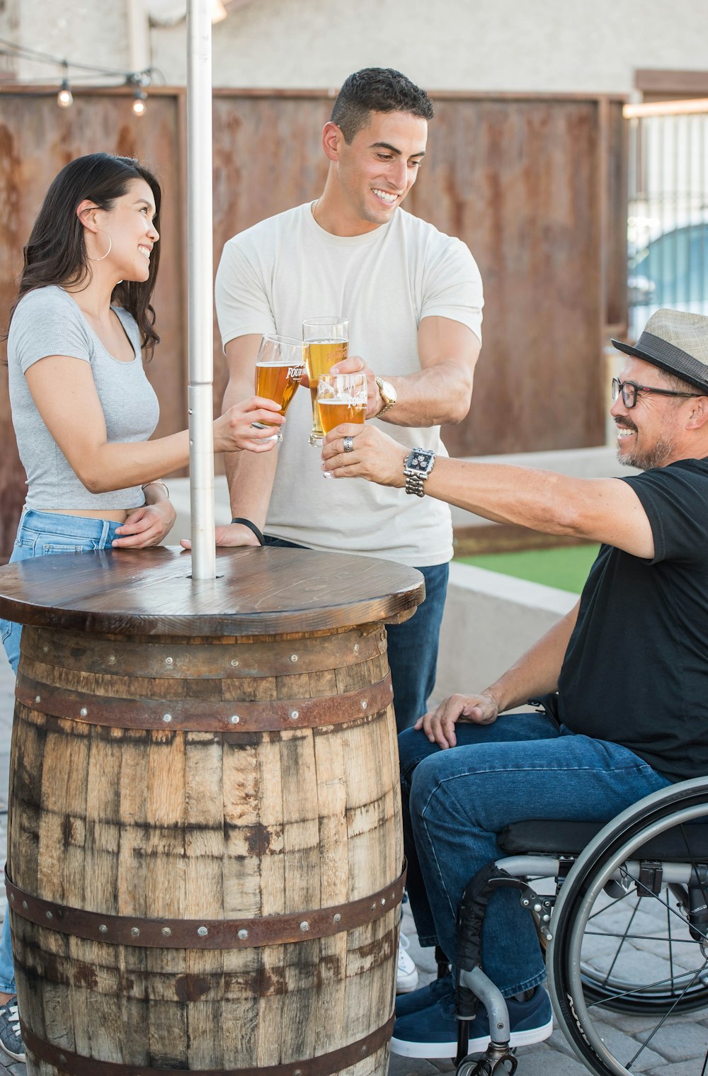 Behinderte und Pärchen werfen sich gegenseitig ein Glas Bier zu