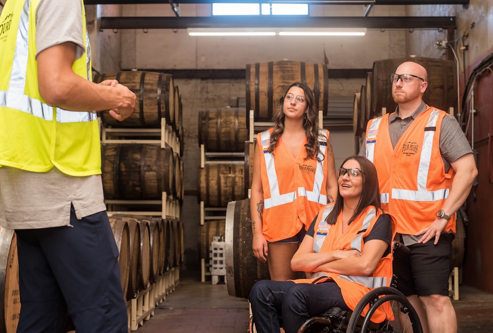 femmes et hommes portant des gilets de sécurité orange