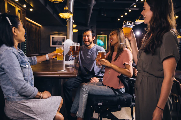 Grupo de amigos conversando e rindo no balcão de um bar