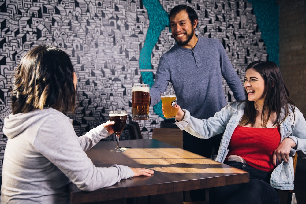 three people drinking beer
