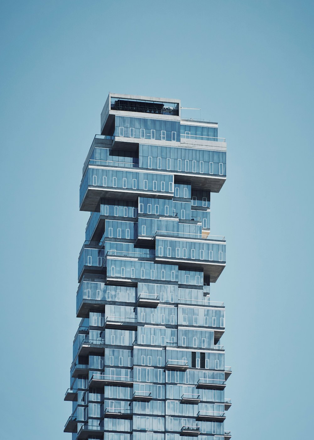 blue high-rise building under a calm blue sky