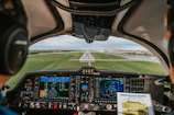 Pilot’s view from the cockpit showing instrument panels and a runway ahead.