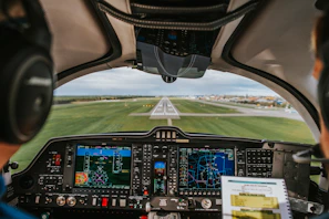 Pilot’s view from the cockpit showing instrument panels and a runway ahead.