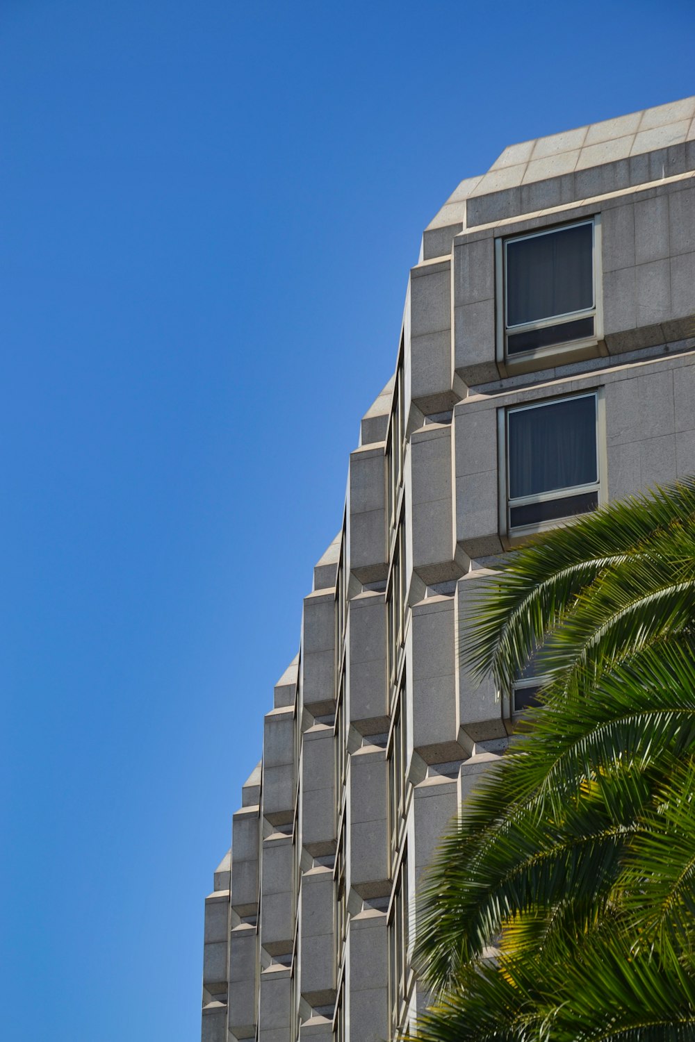 low-angle photography of gray concrete building under blue sky