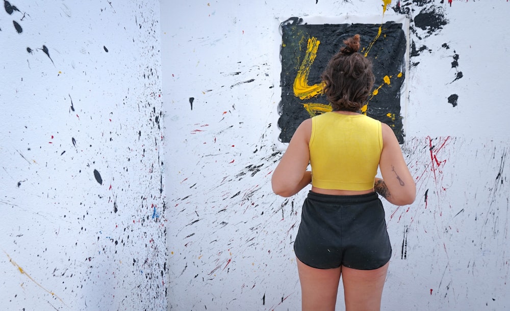 woman in yellow sleeveless top and black shorts