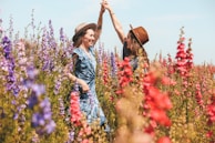 two women holding hands at the flower field