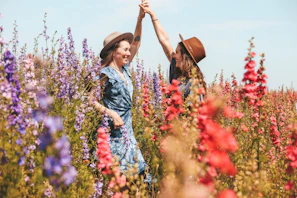 two women holding hands at the flower field