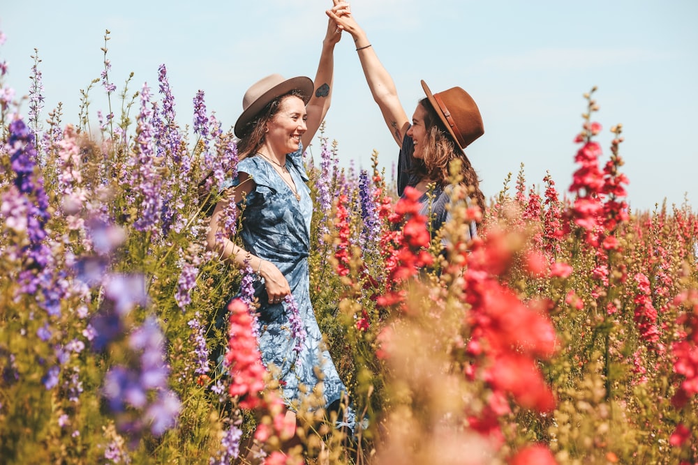 Zwei Frauen halten sich an der Blumenwiese an den Händen