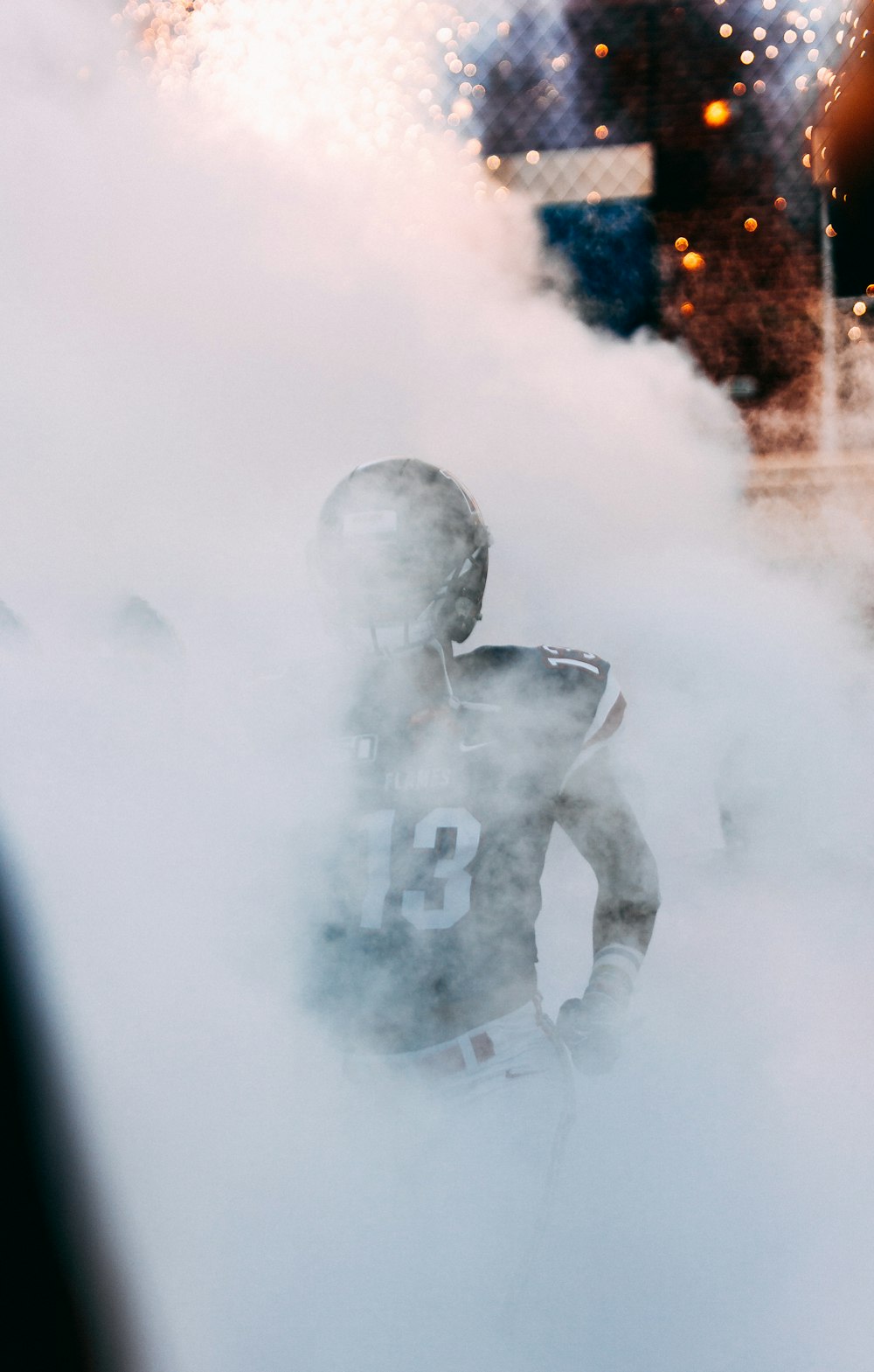 a football player walking through a cloud of smoke