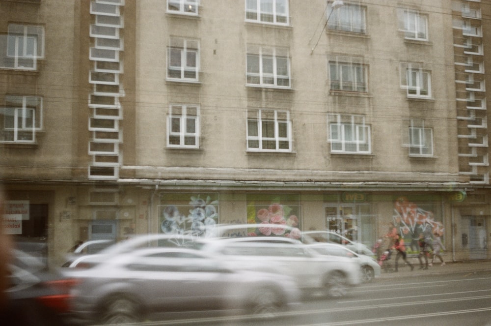 panning photo of cars beside building