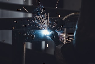 Welding sparks flying as a professional welds metal components.