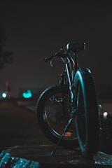 a bicycle parked on the side of a road at night