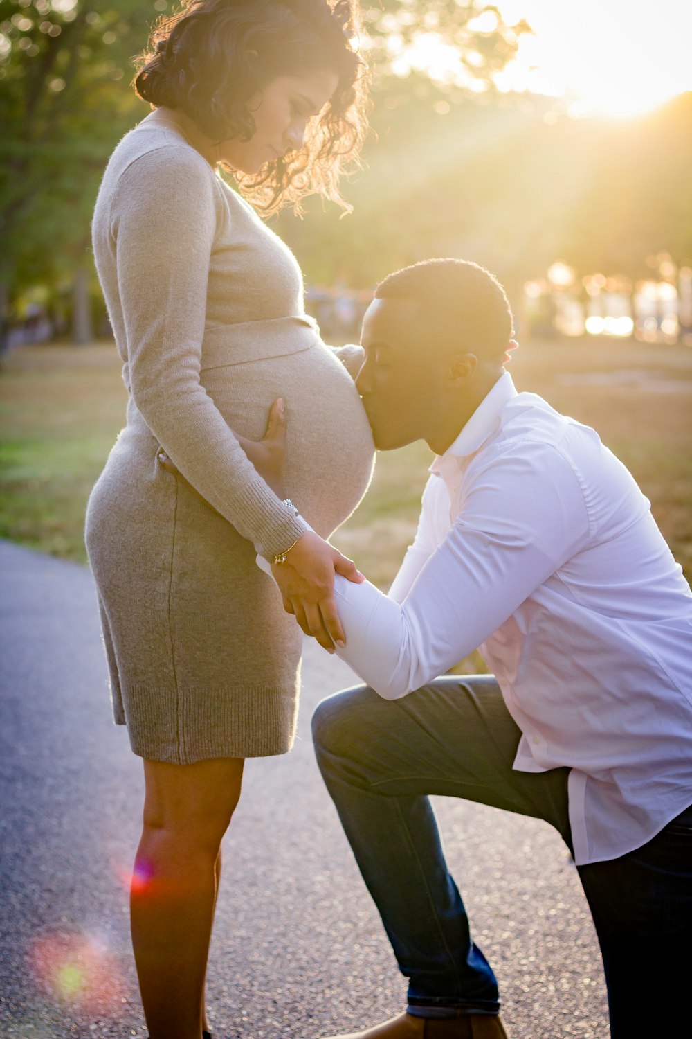 man kneeling in front of pregnant woman