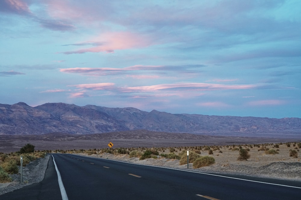 landscape photography of an asphalt road leading to the mountain