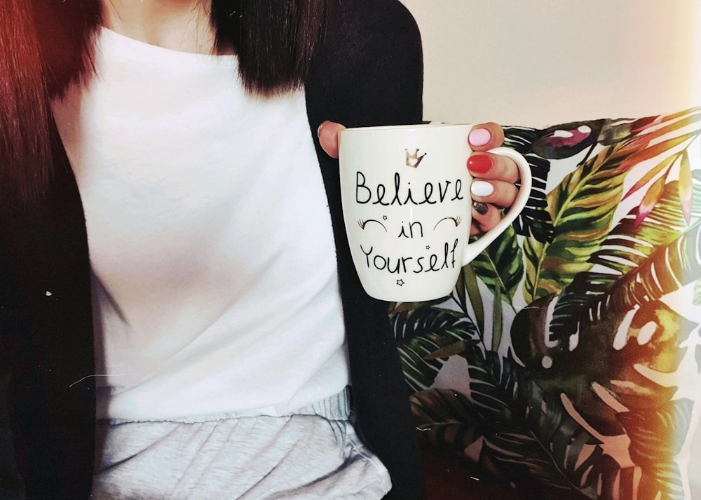 woman wearing black cardigan holding mug