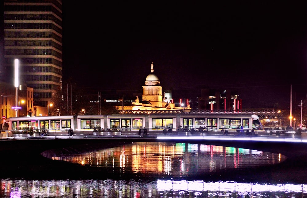 reflection of buildings light on body of water at night