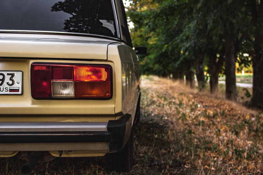 brown vehicle parked beside tree