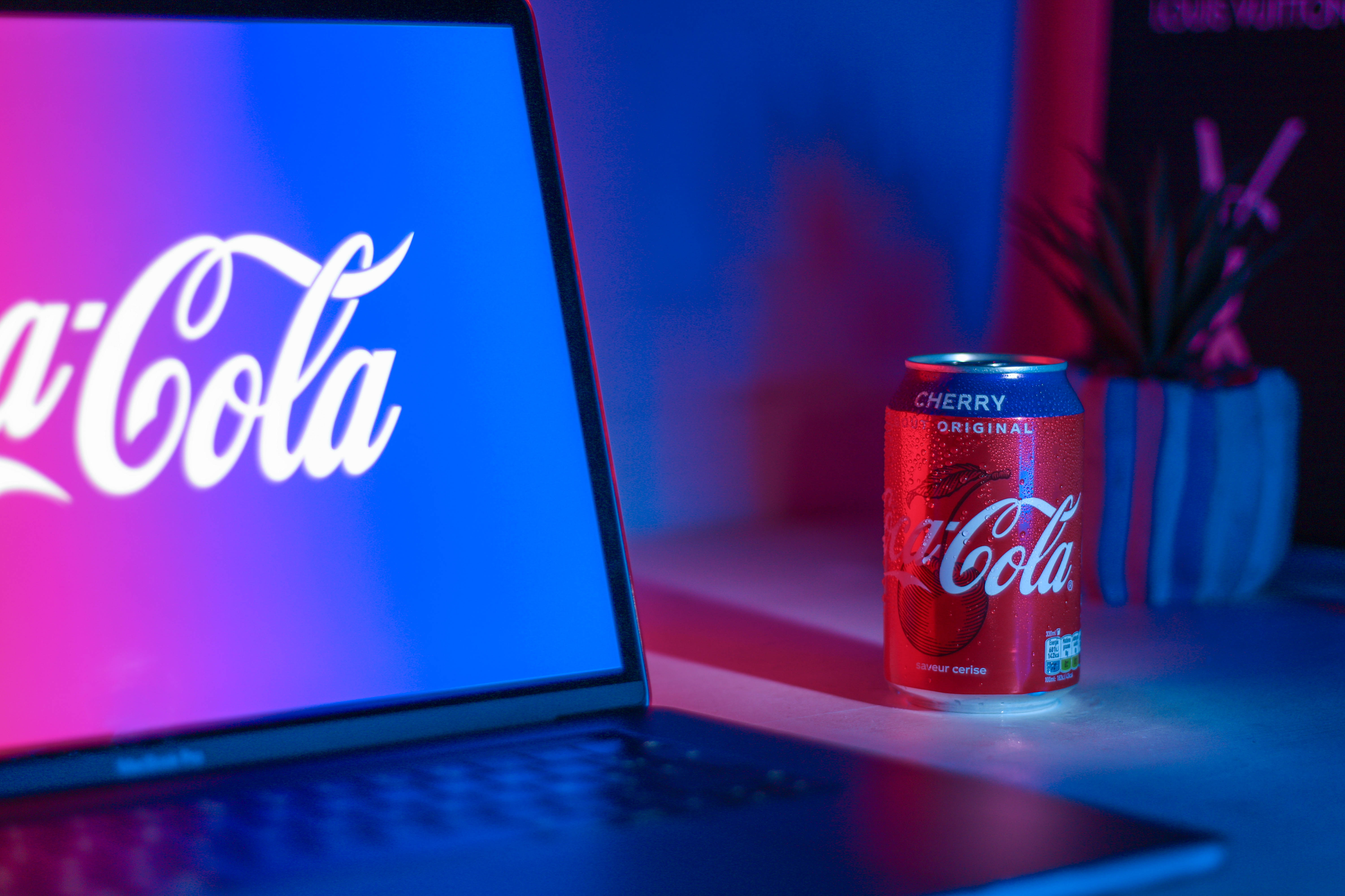 Coke can on a desk on a purple gradient.