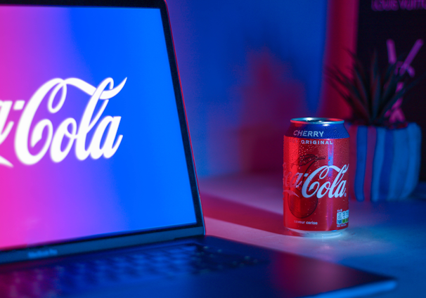 Coca-Cola soda can beside laptop