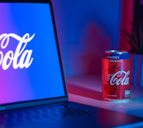 Coca-Cola soda can beside laptop