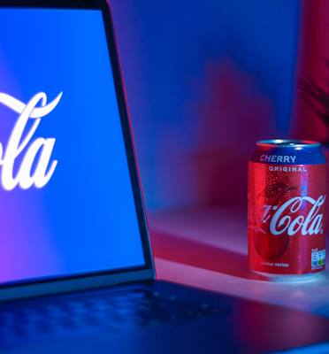 Coca-Cola soda can beside laptop