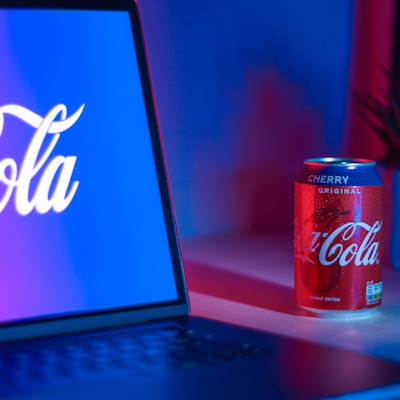 Coca-Cola soda can beside laptop