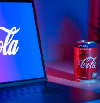 Coca-Cola soda can beside laptop