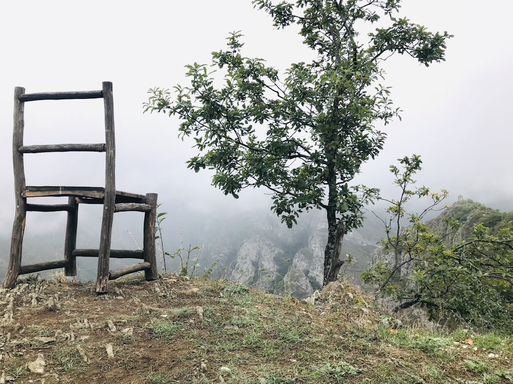 empty gray wooden chair looking at mountain