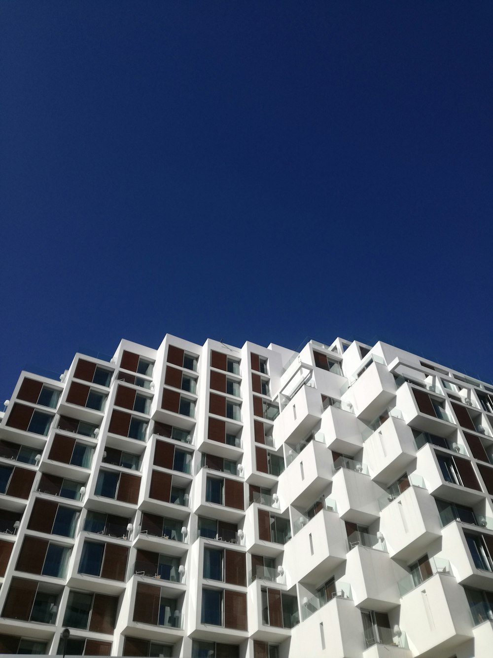 Edifício de concreto branco sob o céu azul durante o dia